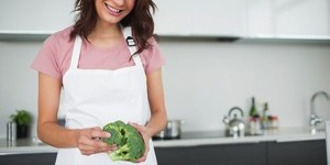 Woman adding broccoli to a pot