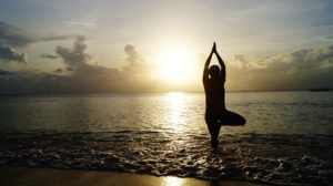 Woman practicing yoga on the beach