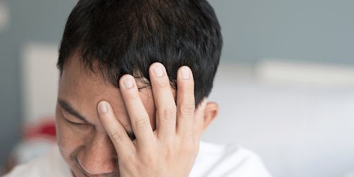 A man clutching his head in pain