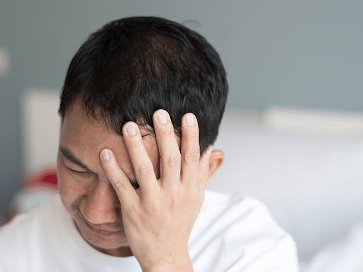 A man clutching his head in pain