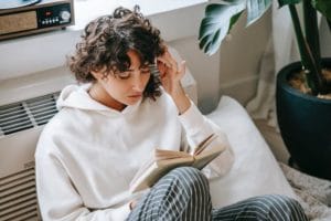 A woman holds her head while reading