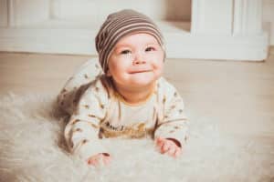A baby crawling on a rug