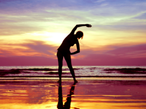 A patient exercising on the beach as a way of managing their migraine symptoms