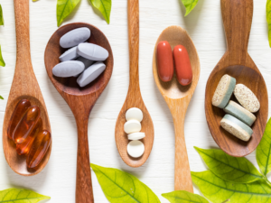 A row of wooden spoons with dietary supplements for migraine management